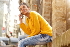 Attractive woman sitting outdoors and talking on cellphone
